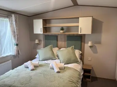 a bedroom with a bed with two towels on it at 10 Borwick Lakes, Carnforth - En suite - King size bed in Carnforth