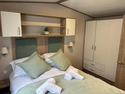 a bedroom with a bed with towels on it at 10 Borwick Lakes, Carnforth - En suite - King size bed in Carnforth