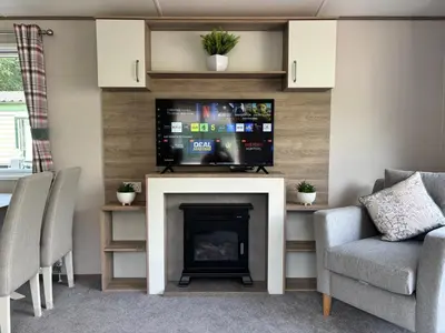 a living room with a fireplace and a flat screen tv at 10 Borwick Lakes, Carnforth - En suite - King size bed in Carnforth