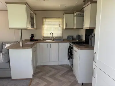 a kitchen with white cabinets and a sink at 10 Borwick Lakes, Carnforth - En suite - King size bed in Carnforth