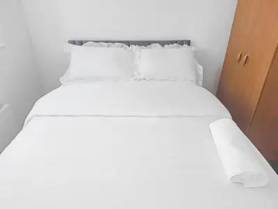 a white bed with white sheets and pillows at 3BR with Ensuite & Downstairs WC in Litherland