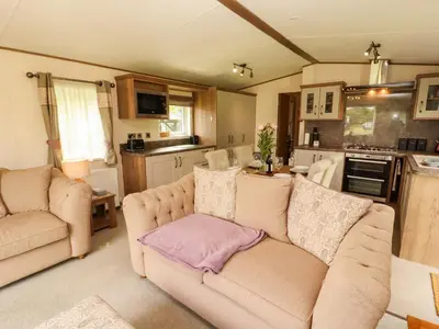 a living room with a couch and a kitchen at 22 Yealand in Carnforth