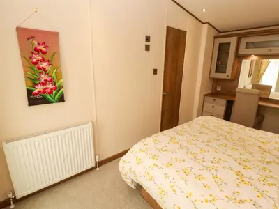 a bedroom with a bed and a painting on the wall at 22 Yealand in Carnforth
