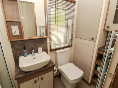a small bathroom with a toilet and a sink at 22 Yealand in Carnforth