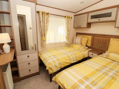 a bedroom with two beds and a tv at 22 Yealand in Carnforth