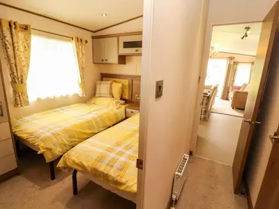 a small room with two beds and a kitchen at 22 Yealand in Carnforth