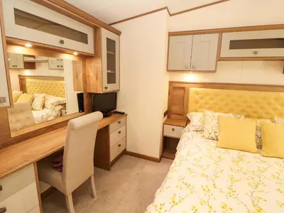 a bedroom with a bed and a desk with a computer at 22 Yealand in Carnforth