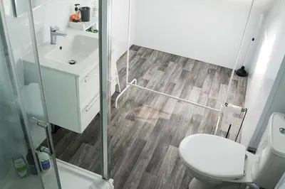a bathroom with a toilet and a shower and a sink at Santiago Suites in Southport