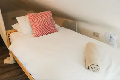 a bed with a pillow and a towel on it at Santiago Suites in Southport