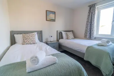 a bedroom with two beds with towels on them at Southport Retreat in Ainsdale