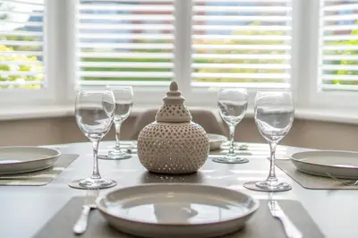 a table with wine glasses and a table set with a table cloth at Southport Retreat in Ainsdale