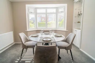 a dining room with a table and chairs and a window at Southport Retreat in Ainsdale
