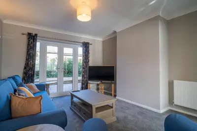 a living room with a blue couch and a tv at Southport Retreat in Ainsdale