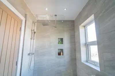a bathroom with a shower with a glass door at Southport Retreat in Ainsdale