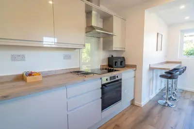 a kitchen with white cabinets and a stove top oven at Southport Retreat in Ainsdale