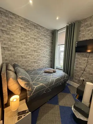 a bedroom with a bed and a brick wall at Almar Hotel Apartments Blackpool in Blackpool