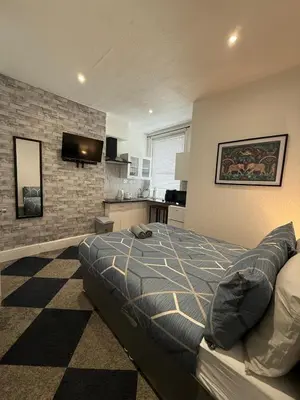 a bedroom with a large bed and a kitchen at Almar Hotel Apartments Blackpool in Blackpool