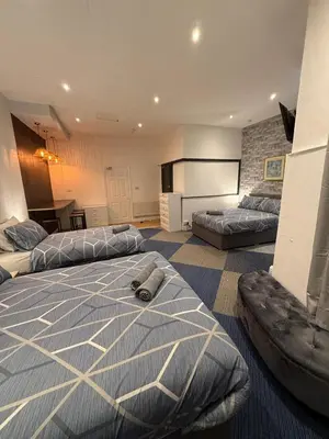 a large bedroom with two beds and a kitchen at Almar Hotel Apartments Blackpool in Blackpool
