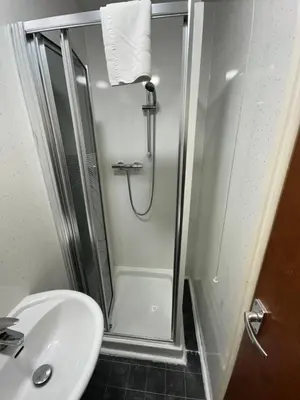 a shower in a bathroom with a sink and a toilet at Tuxford House in Blackpool
