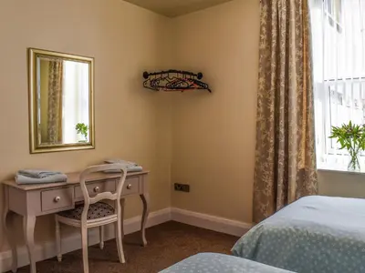 a bedroom with a desk and a bed and a window at Beauty Abounds in Morecambe