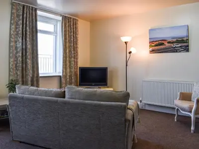 a living room with a couch and a television at Beauty Abounds in Morecambe