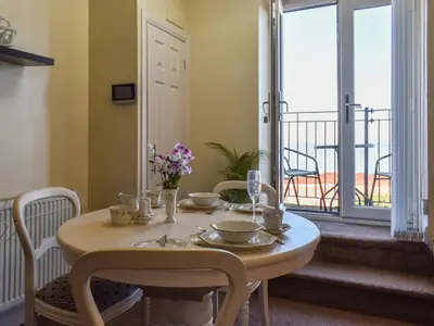 a table and chairs with a table and a balcony at Beauty Abounds in Morecambe