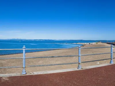 a fence on the beach with the ocean in the background at The Croston in Morecambe