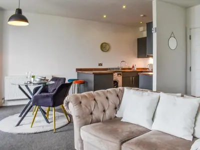 a living room with a couch and a kitchen at The Croston in Morecambe