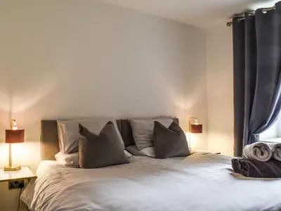a bedroom with a white bed with pillows at The Croston in Morecambe