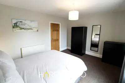 a bedroom with a white bed and a mirror at Captain's Cove in Fleetwood