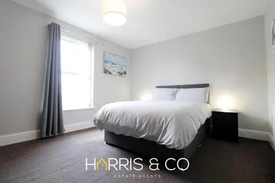 a white bedroom with a bed and a window at Captain's Cove in Fleetwood