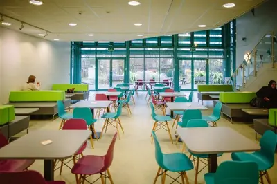 a cafeteria with tables and chairs and people sitting at tables at Waddell Hall, University of Cumbria in Lancaster