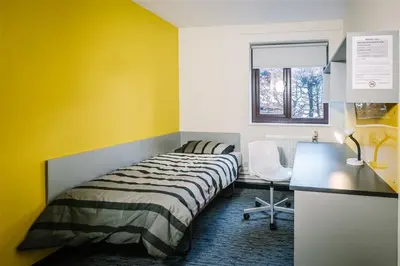 a bedroom with a bed and a desk and a window at Waddell Hall, University of Cumbria in Lancaster