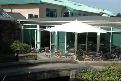 a patio with tables and chairs and an umbrella at Waddell Hall, University of Cumbria in Lancaster