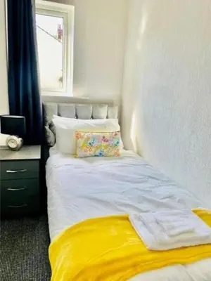 a bedroom with a bed with a yellow blanket at Blackpool Pleasure Beach whole Holiday Home! in Blackpool