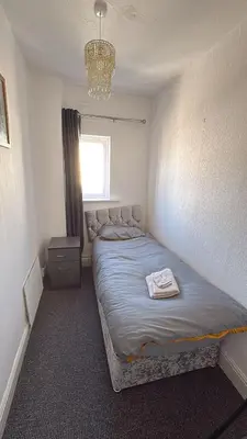 a bedroom with a bed in a room with a chandelier at Blackpool Pleasure Beach whole Holiday Home! in Blackpool