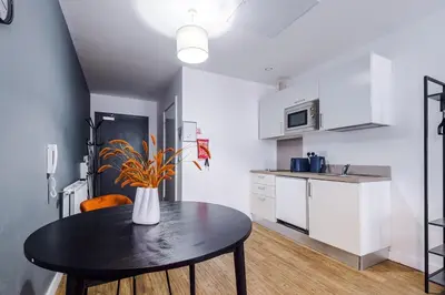 a kitchen with a table with a vase on it at Newly renovated stylish studio Merseyside Moorfields in Liverpool