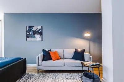 a living room with a couch and a blue wall at Newly renovated stylish studio Merseyside Moorfields in Liverpool