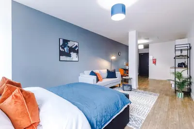 a bedroom with a bed and a living room at Newly renovated stylish studio Merseyside Moorfields in Liverpool
