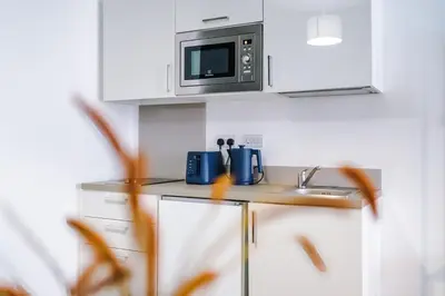 a kitchen with a sink and a microwave at Newly renovated stylish studio Merseyside Moorfields in Liverpool