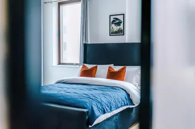a bedroom with a bed with orange pillows at Newly renovated stylish studio Merseyside Moorfields in Liverpool
