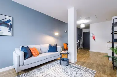 a living room with a couch and a blue wall at Newly renovated stylish studio Merseyside Moorfields in Liverpool