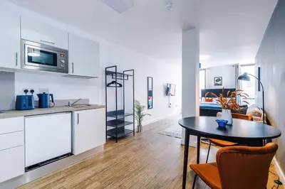 a kitchen and a dining room with a table in a room at Newly renovated stylish studio Merseyside Moorfields in Liverpool