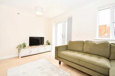 a living room with a couch and a flat screen tv at Modern 3 Bedroom House in Kirkdale Liverpool in Liverpool