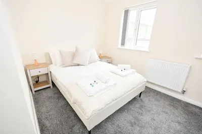 a white bed in a room with a window at Modern 3 Bedroom House in Kirkdale Liverpool in Liverpool