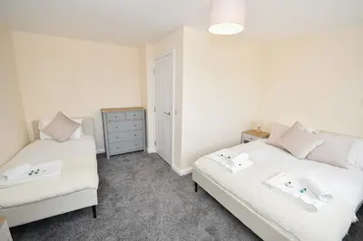 a bedroom with two beds and a dresser at Modern 3 Bedroom House in Kirkdale Liverpool in Liverpool