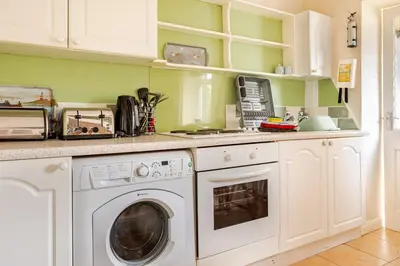 a kitchen with a washer and dryer at Cosy, coastal cottage- Beach, Pub and shop nearby in Haverigg
