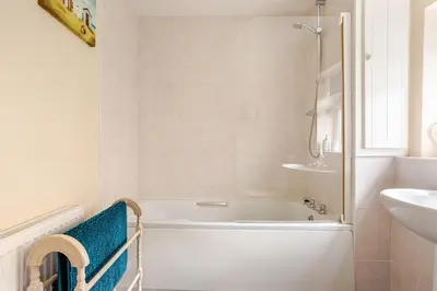 a white bathroom with a tub and a sink at Cosy, coastal cottage- Beach, Pub and shop nearby in Haverigg
