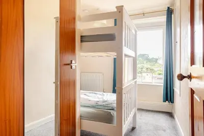 a bedroom with a bunk bed and a window at Cosy, coastal cottage- Beach, Pub and shop nearby in Haverigg