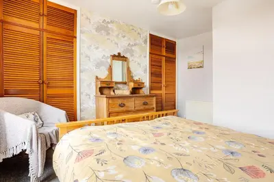 a bedroom with a bed with a dresser and a mirror at Cosy, coastal cottage- Beach, Pub and shop nearby in Haverigg